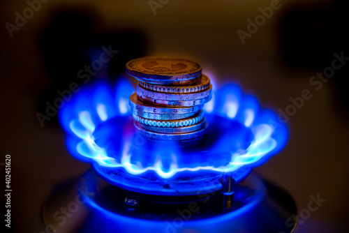 Gas stove, with fire lit and coins. Gas cost. photo