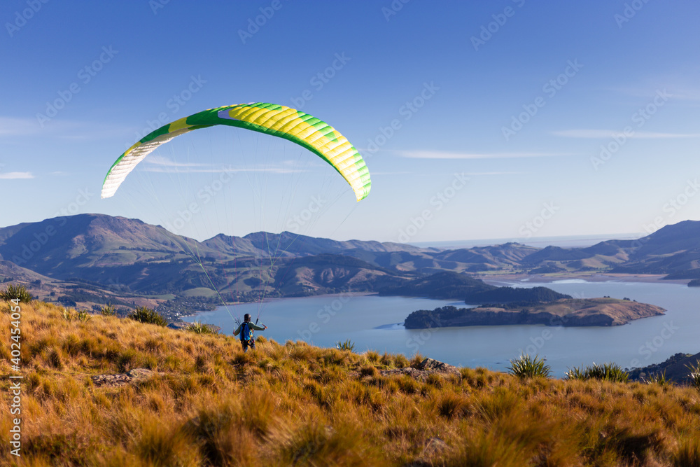 Man on a bright parachute running towards beautiful landscape Man on a bright parachute running towards beautiful landscape