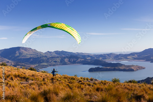 Man on a bright parachute running towards beautiful landscape