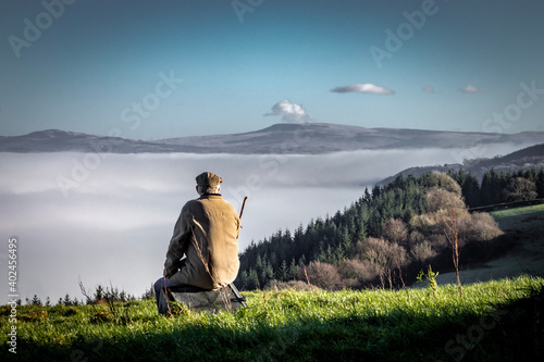 Old man sitting on the grass enjoying the view