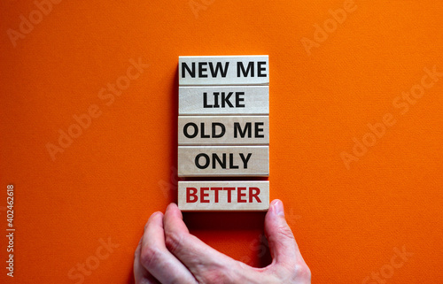 Better new me symbol. Men hand. Wooden blocks with words 'new me like old me only better'. Beautiful orange background, copy space. Business and new me concept.