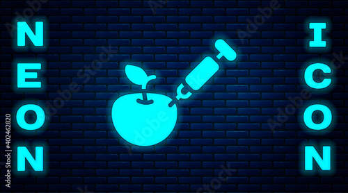 Glowing neon Genetically modified apple icon isolated on brick wall background. GMO fruit. Syringe being injected to apple. Vector.