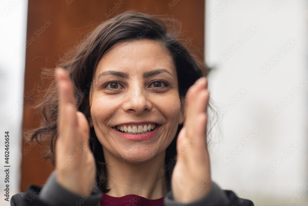 Frau mit offenen dunklen Haaren außen und lachend Frau mit offenen dunklen Haaren außen und lachend