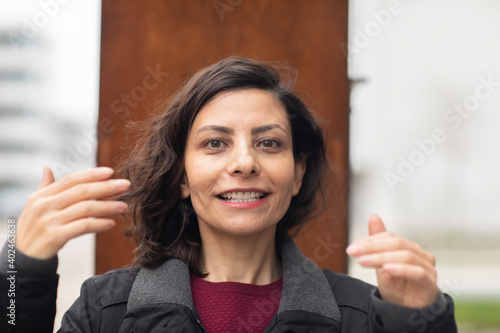 Frau  mit offenen dunklen Haaren außen  und lachend