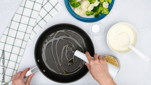 Chef pouring olive oil into frying pan. Vgetable casserole step by step recipe, cooking process, flat lay photo