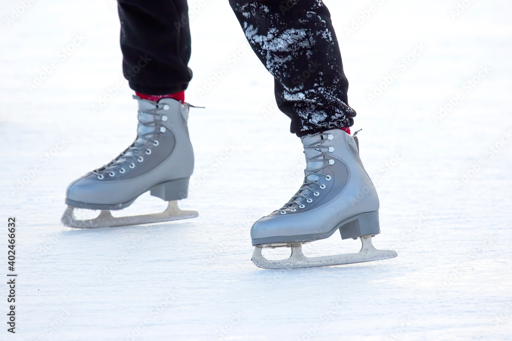 feet on the skates of a person rolling on the ice rink feet on the skates of a person rolling on the ice rink