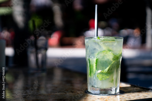 tasty lime mojito served at a bar with a black straw