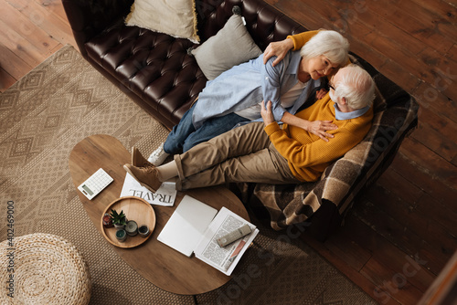 Quadro su tela top view of happy elderly couple looking at each other while hugging on couch at