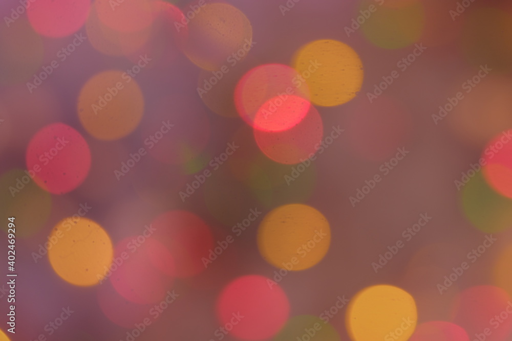 Background of defocused christmas lights on christmas tree full of pink color mist.