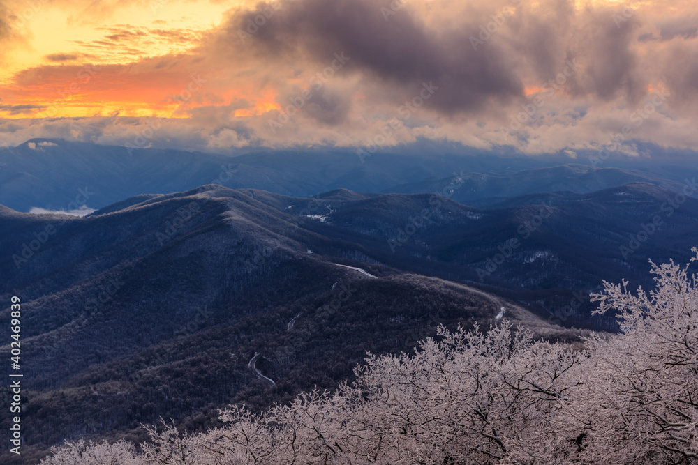 Devil's Knob Overlook – Blue Ridge Mountains with low-level clouds, ice covered trees, pink and yellow clouds at sunset