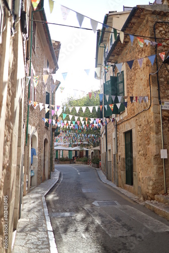 Sunny road with colorful decoration in an old Spanish mountain village Fornalutx, Mallorca, Spain