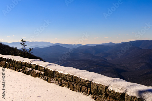 Ravens Roost Overlook – View of Blue Ridge Mountains and ridges with snow covered stone wall in foreground