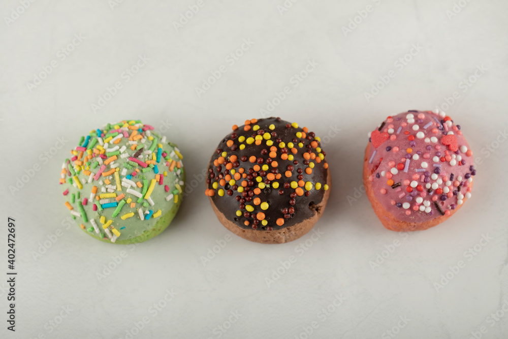 Colorful sweet small doughnuts on a white background