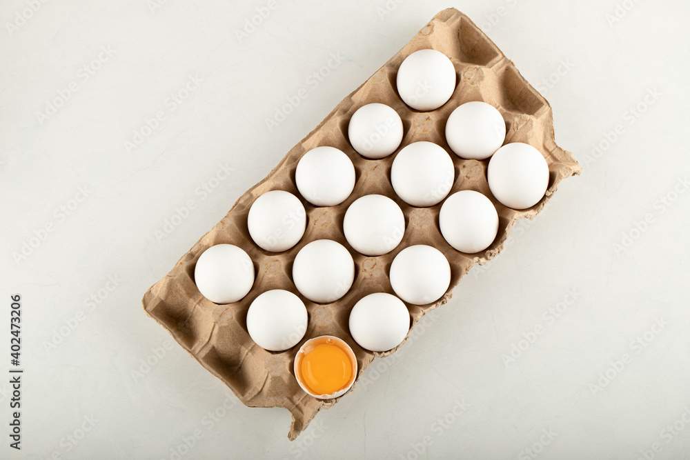 Raw chicken eggs in egg box on a white background Raw chicken eggs in egg box on a white background