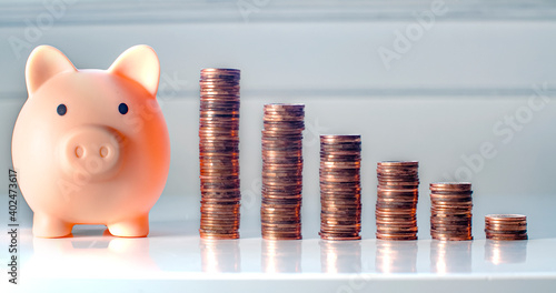 Foto A porky bank with coins on a grey background