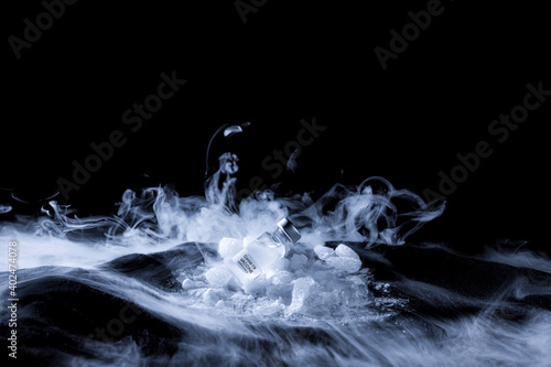 A Covid-19 vaccine preserved at very low temperature with carbon dioxide (dry ice) with a lot of steam photo