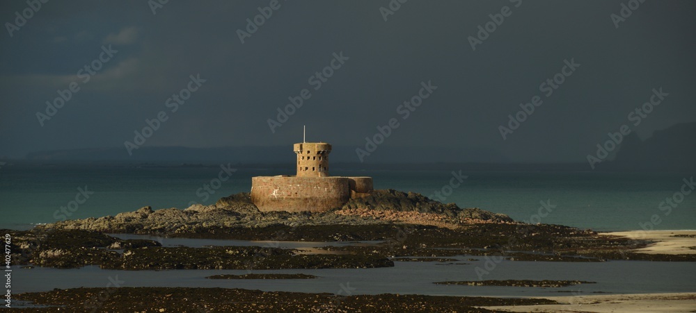 Rocco tower and St Ouen's Bay, Jersey, U.K. Telephoto Winter image with moody skies.