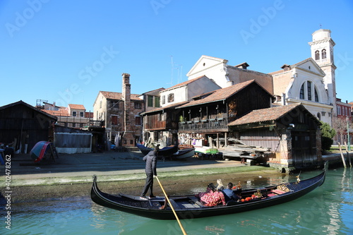 gondola with a repari place and people passing by in venice on a sunny day photo