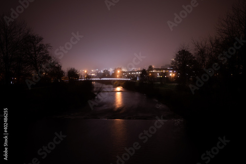 Stadt mit Fluss im Vordergrund in der Nacht © Adrian Schneider