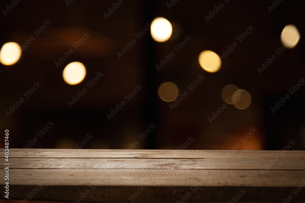 empty wooden table on blurred light gold bokeh of cafe restaurant on dark background, blurred cafe interior place for your products on the table empty wooden table on blurred light gold bokeh of cafe restaurant on dark background, blurred cafe interior place for your products on the table