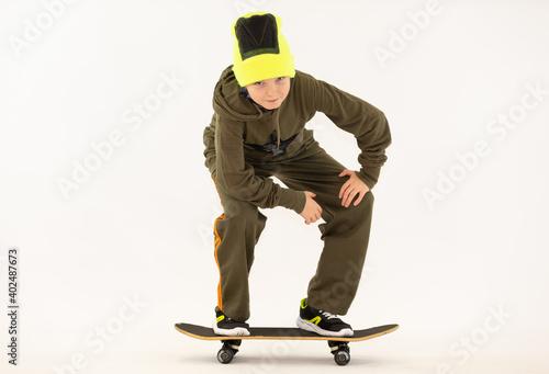 boy on a skateboard, cheerful boy with red hair and a cap on a white background, space for text, positive, smiling hip hop boy, sits, stands, rides, lies