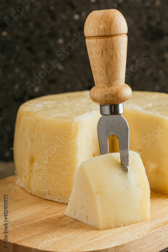 Spanish palmero cheese, on a wooden cheese board with utensils such as fork, knife, all on a stone background. 16 photo