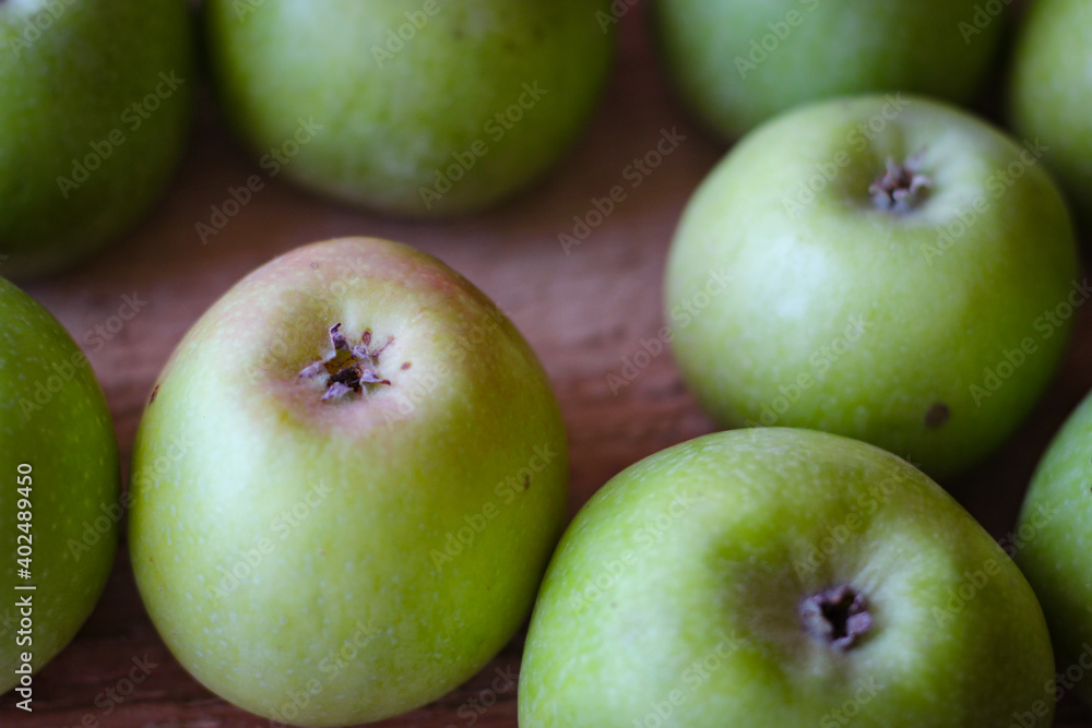 Green apples stand on a wooden surface Green apples stand on a wooden surface