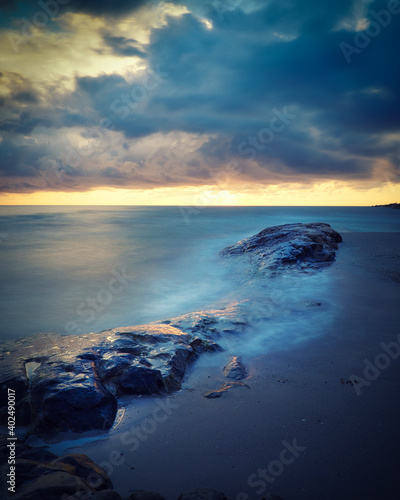 Sunset at the beach with rocks in the water, Spain © ruthlaguna