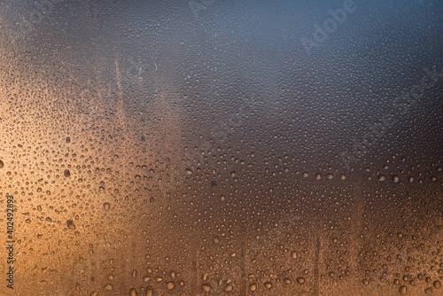 Water drops frozen to a window at sunrise