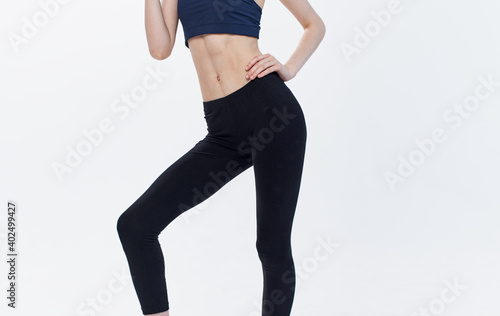 woman in sportswear on light background side view leggings t-shirt fitness