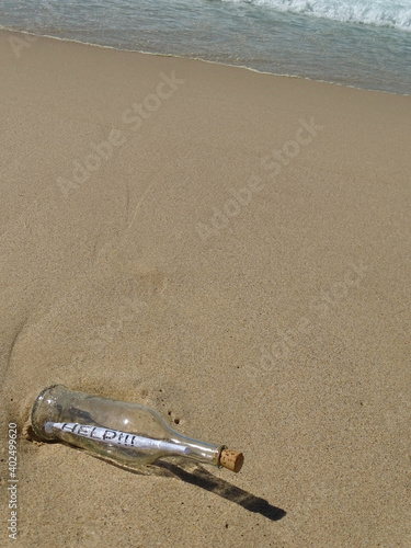 Message in a bottle washed up on a sandy beach.