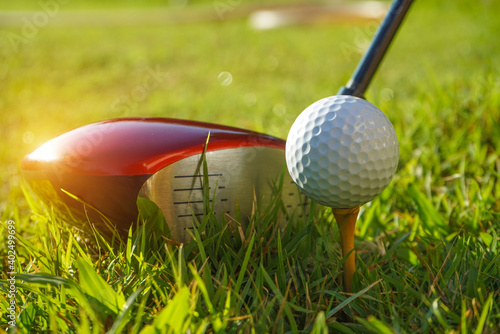 Golf club and ball on tee in grass. Golf balls on the golf course with golf clubs ready for the first short. In the morning, with the beautiful light. 