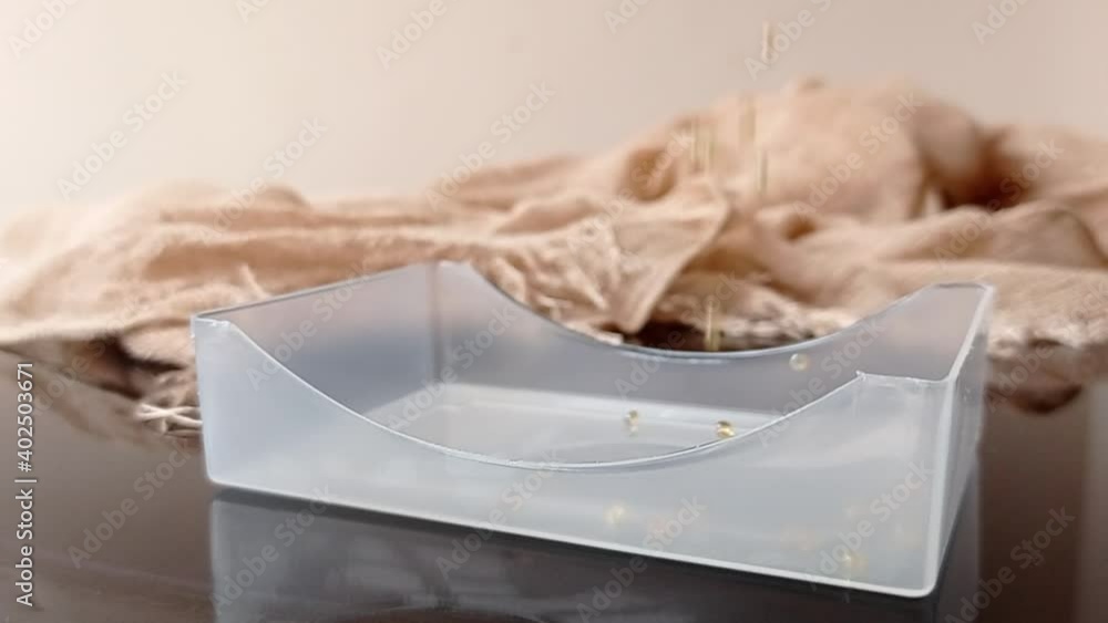 pouring small pearls into a small box pouring small pearls into a small box