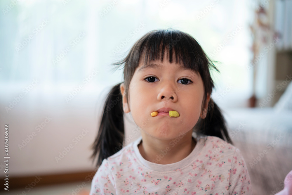 An Asian girl uses her mouth to hold the biscuits. Playing as the fangs sticking out An Asian girl uses her mouth to hold the biscuits. Playing as the fangs sticking out