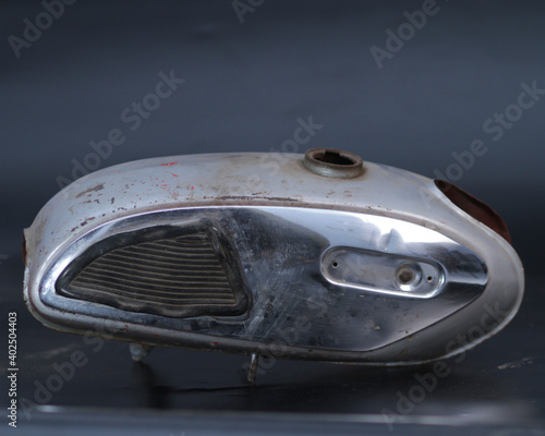 Silver tank of a historic motorbike. Motorbike fuel tank vintage isolated black background. Detail of a grunge vintage motorcycle. Photo of an old gas tank. motorbike fuel tank retro and classic.