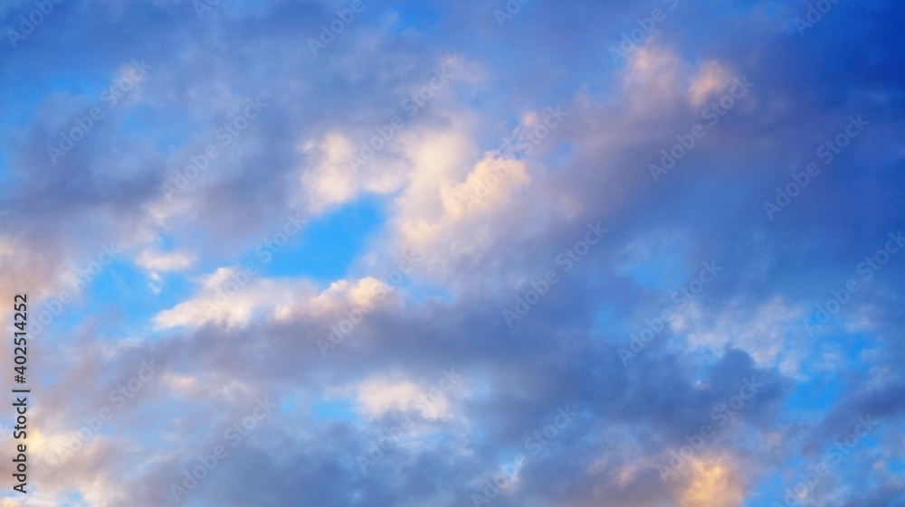 View of the blue sky with white and gray fluffy clouds on a sunny day
