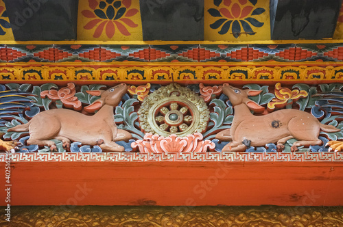 Carved wood symbol of the Buddha's first sermon in the deer park in Sarnath with deers and dharmachakra or dharma wheel in Punakha dzong, Bhutan