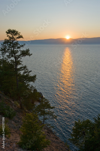 The setting sun is reflected in the water of Lake Baikal.