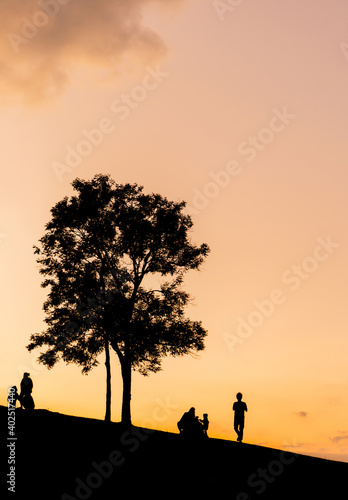 Silhouette of father mother and daughter groups playing at sunset in evening time  Happy family concept.