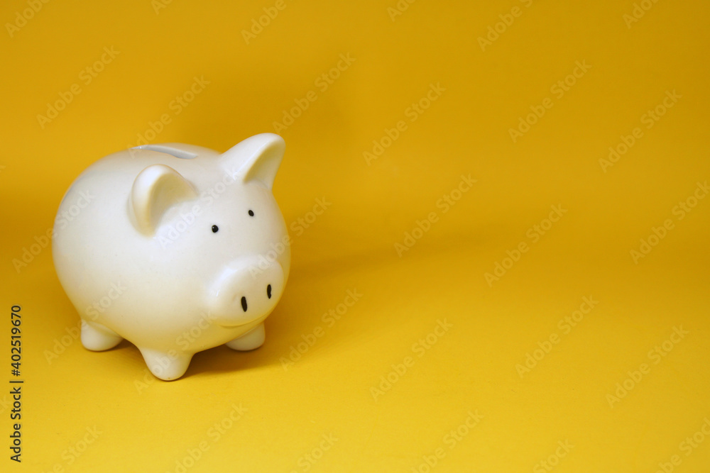 White Piggy bank isolated on yellow background with copy space for text message - Fund , Investment , Saving money - yellow concept of Banking and finance concept White Piggy bank isolated on yellow background with copy space for text message - Fund , Investment , Saving money - yellow concept of Banking and finance concept