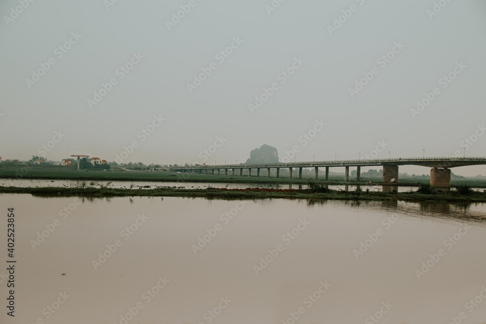 Cinematic dark and moody scenery of a bridge over the river in Ninh Binh, Vietnam