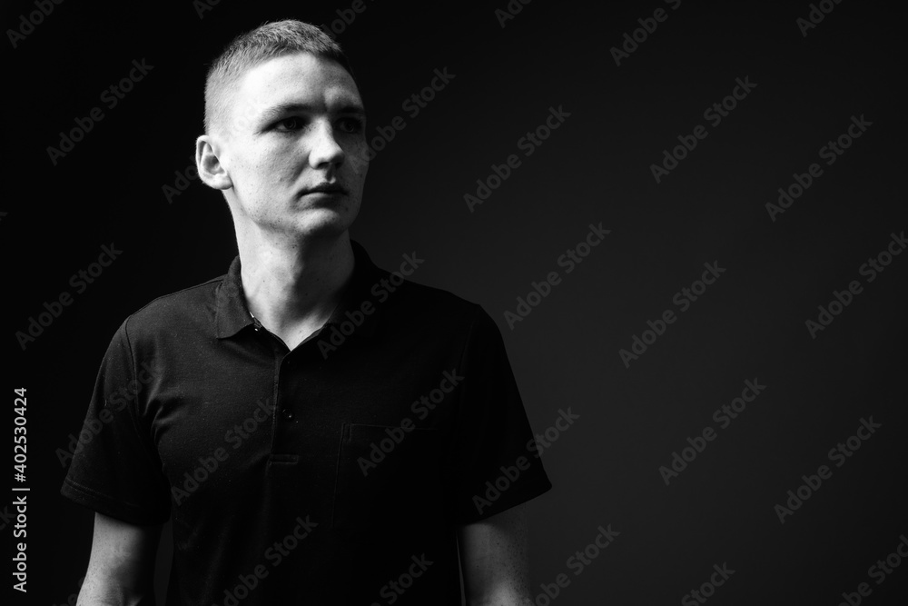 Young man against black background in black and white Young man against black background in black and white