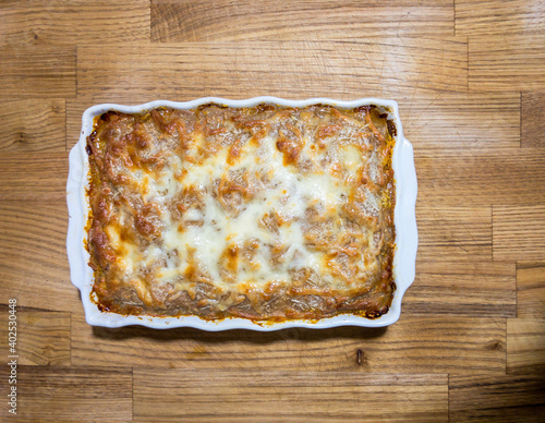 Homemade fresh lasagna on a wooden surface, top view