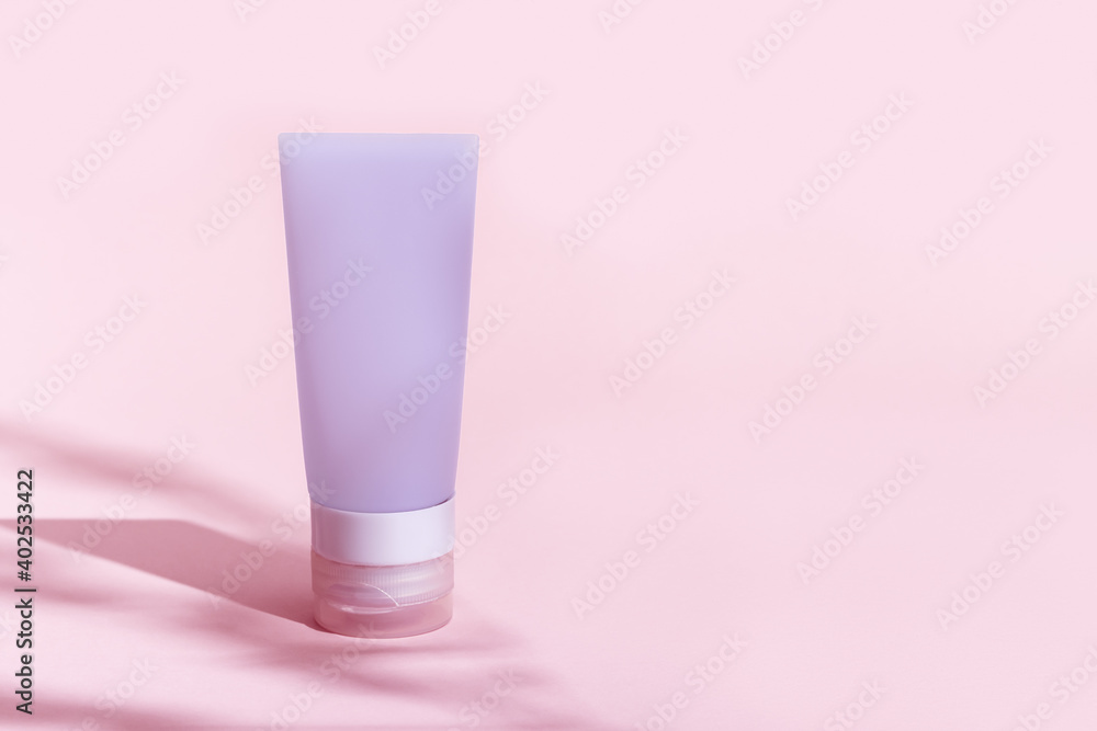 Cosmetic tube for cream, gel, lotion. Beauty product package, mock up plastic container with hard shadows on pink colored background Cosmetic tube for cream, gel, lotion. Beauty product package, mock up plastic container with hard shadows on pink colored background