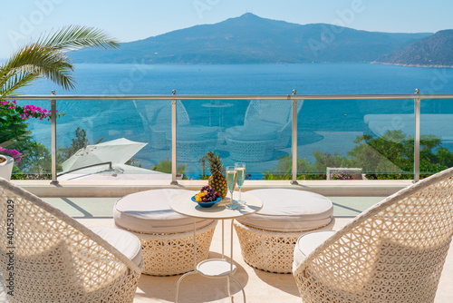 Romantic summer vacation view. Luxury travel balcony with ocean view.  Drinks and fruits on table holiday destination.