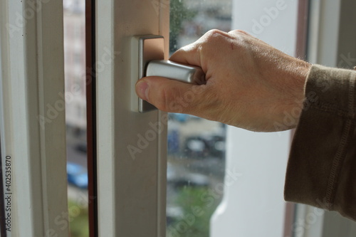 Hand open white plastic pvc window at home 