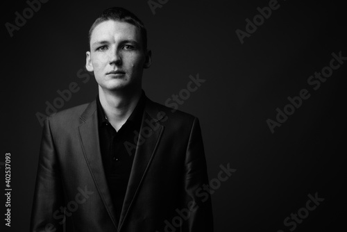 Studio shot of young businessman against brown background