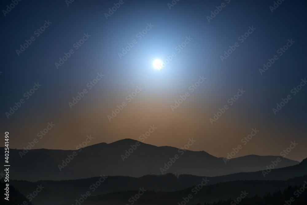 Panorama of mountains with full moon on night sky and stars