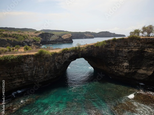 Panoramic view of Pasih Uug Broken beach tropical rock arch tunnel cliff cove natural bridge Nusa Penida Bali Indonesia photo