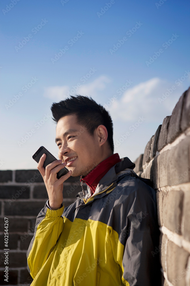 A young man use the walkie talkie in the Great Wall Tourism A young man use the walkie talkie in the Great Wall Tourism